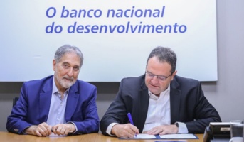 Diretor Nelson Barbosa assina documento ao lado do presidente da Emgea, Fernando Pimentel