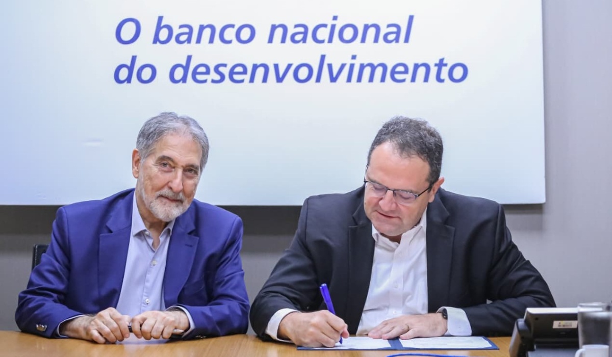 Diretor Nelson Barbosa assina documento ao lado do presidente da Emgea, Fernando Pimentel