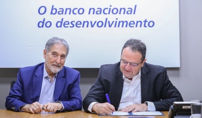 Diretor Nelson Barbosa assina documento ao lado do presidente da Emgea, Fernando Pimentel